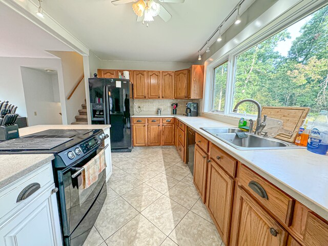 kitchen with black appliances, light tile patterned floors, sink, rail lighting, and ceiling fan