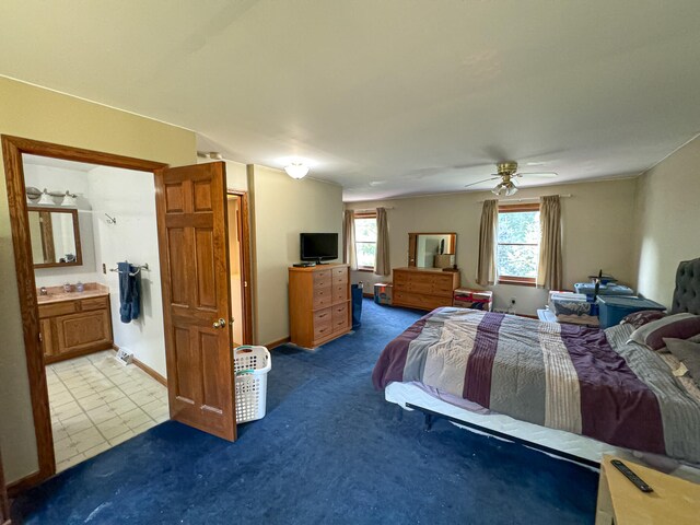 bedroom featuring ceiling fan, light carpet, and ensuite bathroom