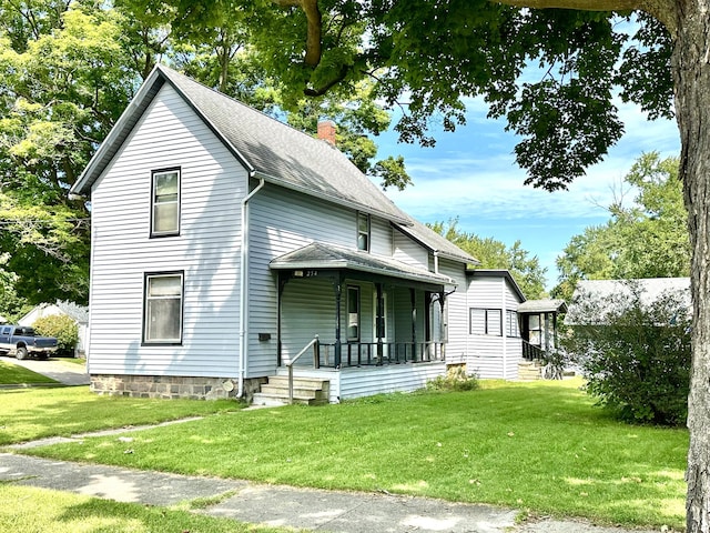 view of front of home with a front lawn, covered porch, a chimney, and a shingled roof