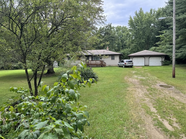 view of yard featuring a wooden deck, a garage, and an outbuilding