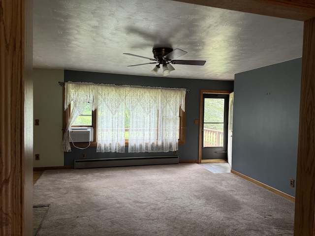 spare room with ceiling fan, carpet floors, baseboard heating, and a healthy amount of sunlight