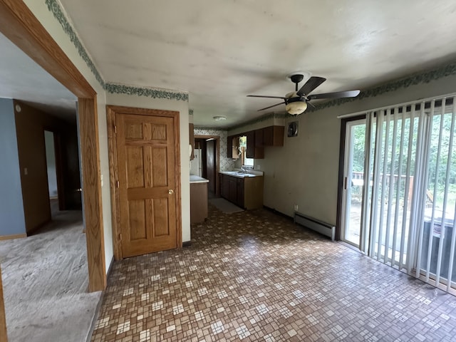 unfurnished living room featuring a baseboard radiator, sink, ceiling fan, and tile patterned flooring