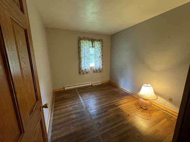 unfurnished room with dark wood-type flooring and baseboard heating