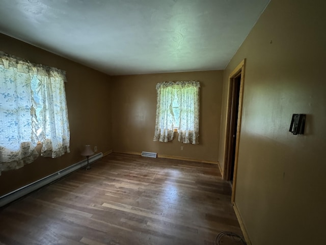 spare room with baseboard heating and hardwood / wood-style floors