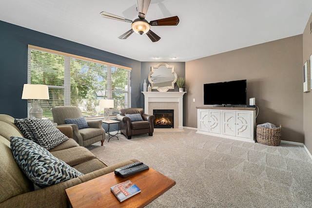 living room with carpet floors, ceiling fan, and a tile fireplace