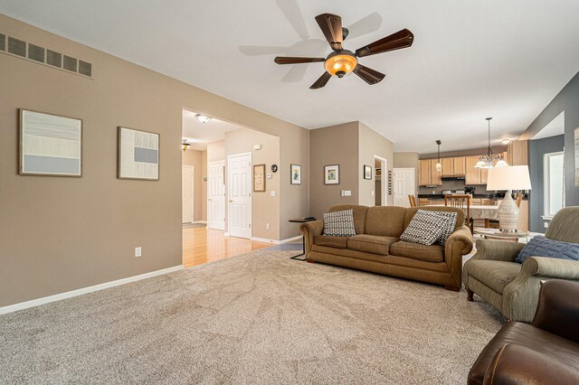 living room with ceiling fan and light colored carpet