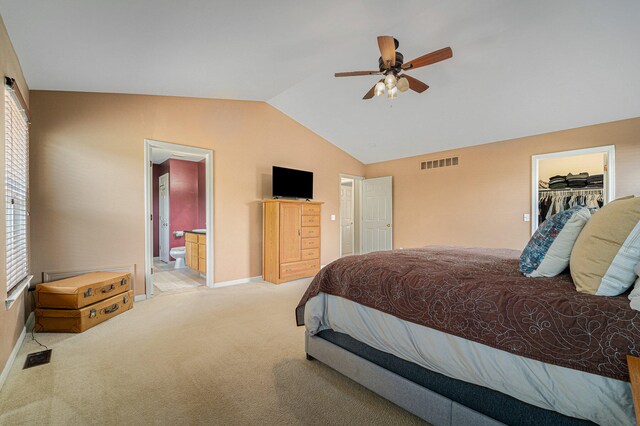 carpeted bedroom with ceiling fan, a spacious closet, a closet, vaulted ceiling, and ensuite bathroom