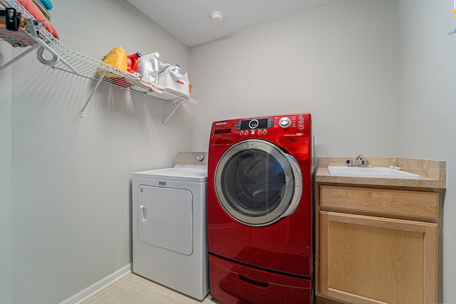 laundry area with separate washer and dryer, sink, light tile patterned floors, and cabinets