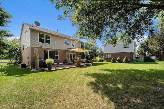 rear view of property with a wooden deck, cooling unit, and a yard