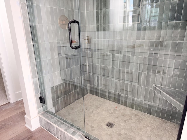 bathroom featuring a shower stall and wood finished floors