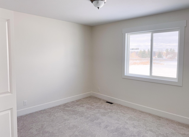 carpeted spare room featuring visible vents and baseboards