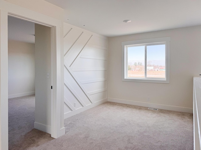 carpeted empty room with visible vents and baseboards