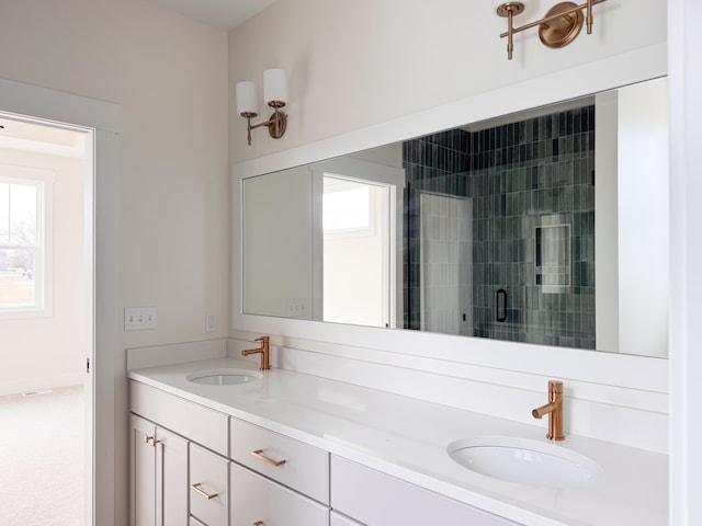 full bathroom featuring double vanity, a stall shower, and a sink