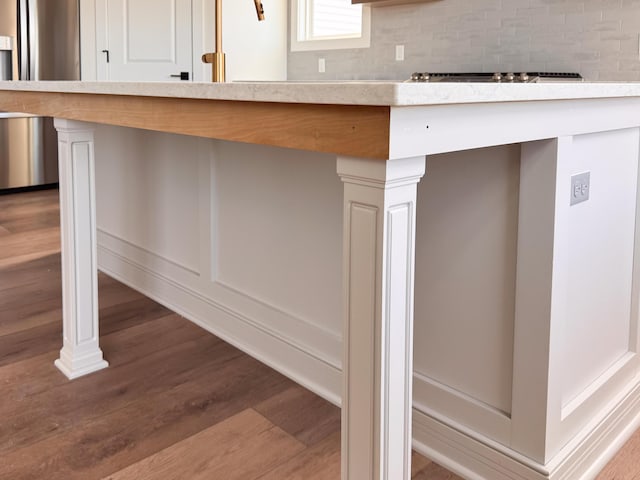 room details featuring light countertops, tasteful backsplash, and wood finished floors