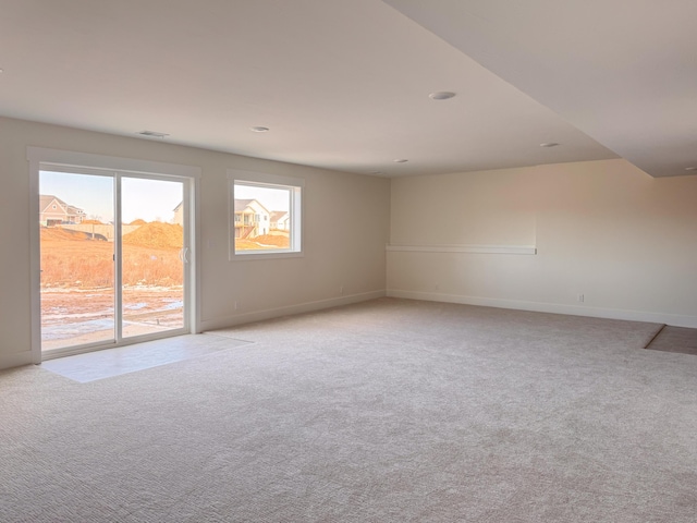 empty room with light carpet, baseboards, and visible vents