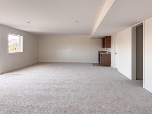 unfurnished room with light carpet and baseboards