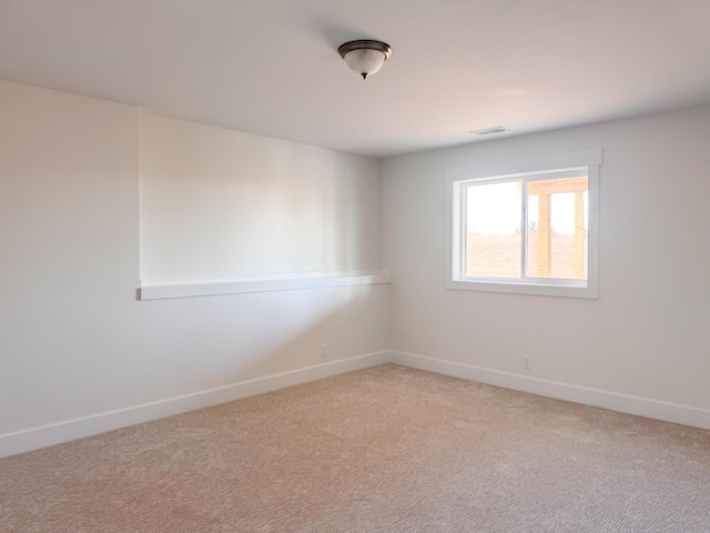 unfurnished room featuring light colored carpet, visible vents, and baseboards