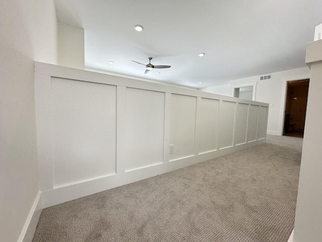 spare room featuring ceiling fan and light colored carpet