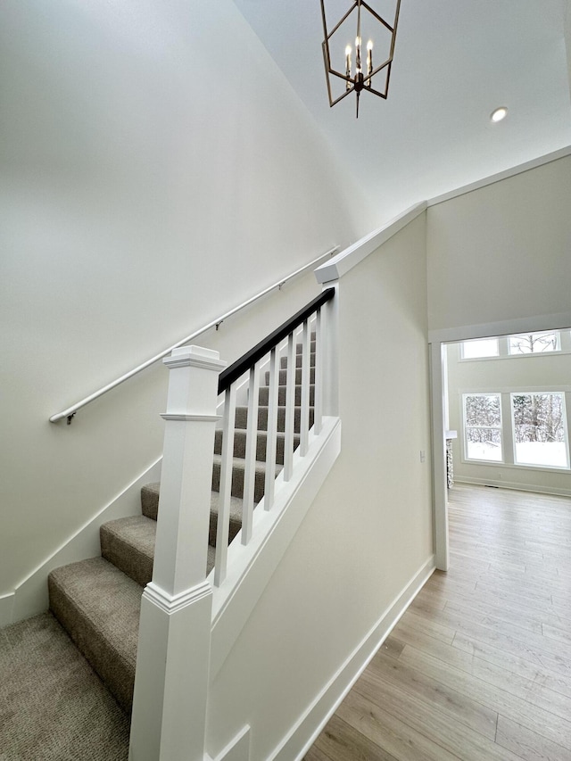 staircase with a chandelier and hardwood / wood-style flooring