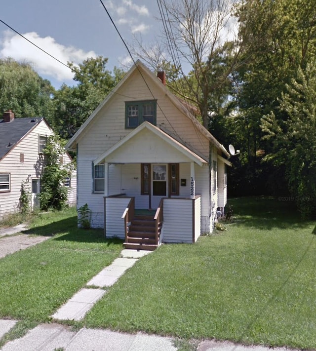 bungalow with covered porch and a front lawn