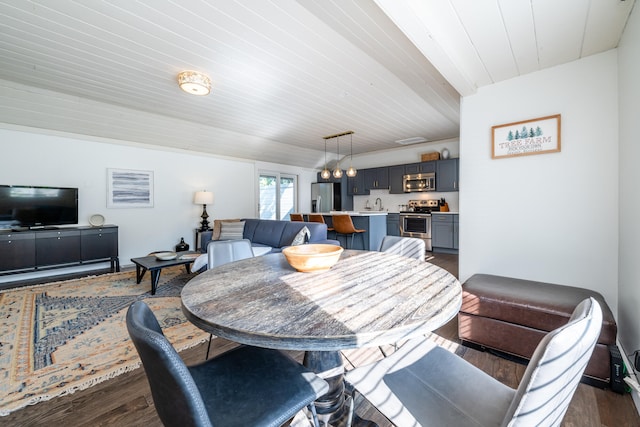 dining area with sink and dark wood-type flooring