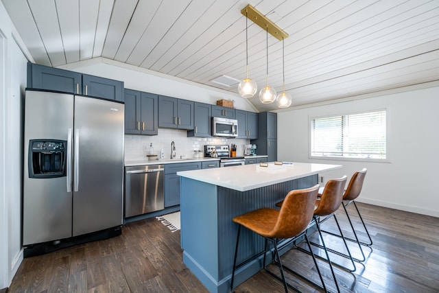 kitchen featuring stainless steel appliances, dark wood-type flooring, decorative light fixtures, and a center island