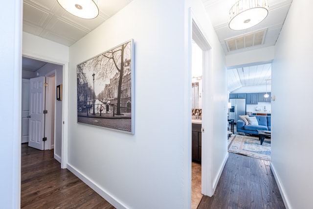 hallway with lofted ceiling and hardwood / wood-style floors