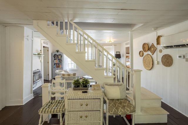 stairs featuring hardwood / wood-style floors and a wall unit AC