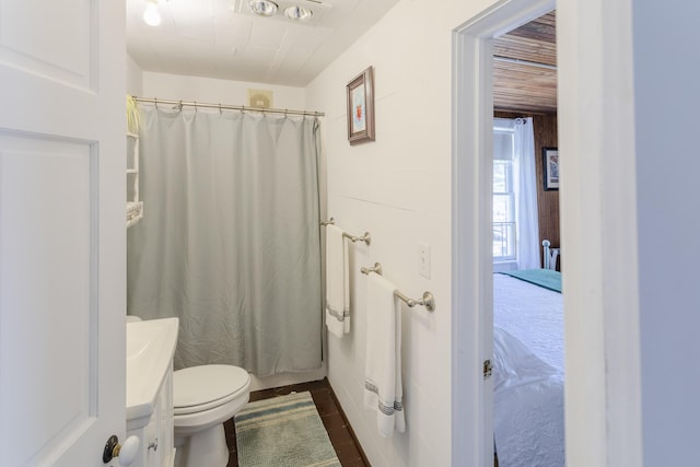 full bath featuring a shower with shower curtain, toilet, and vanity