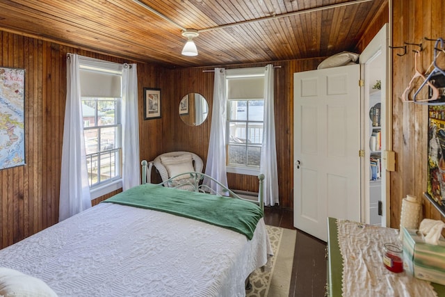 bedroom with wooden walls and wood ceiling