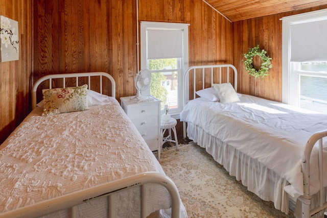 bedroom with lofted ceiling, wooden walls, and wooden ceiling