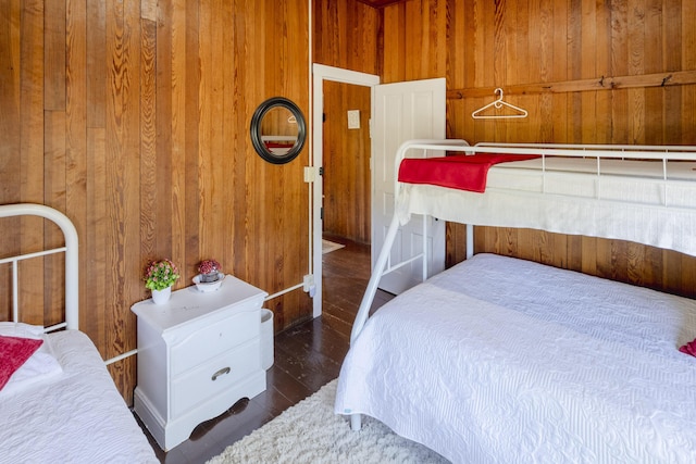 bedroom with wood walls and wood finished floors