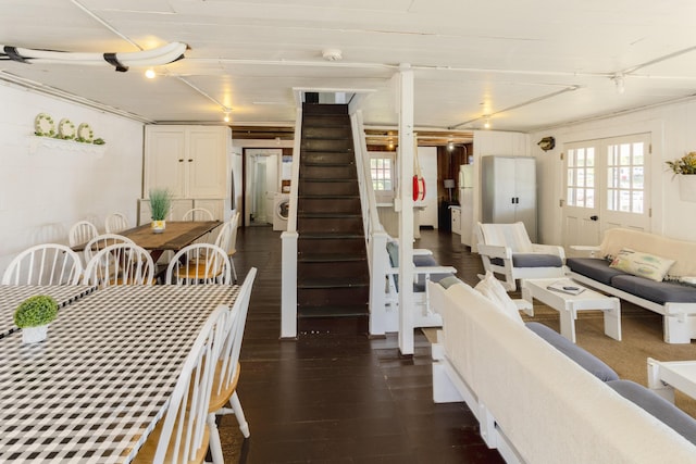 dining space with rail lighting, washer / dryer, dark wood finished floors, and stairs