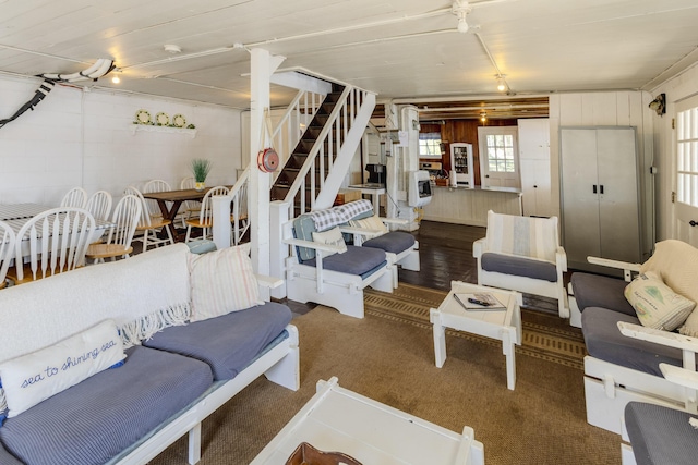 living room with stairway, concrete block wall, and wood finished floors