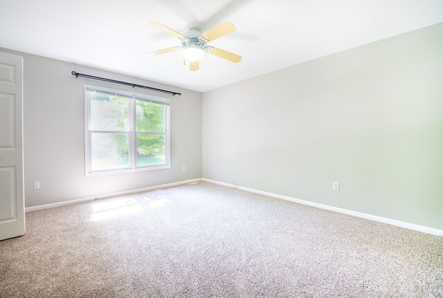 carpeted spare room featuring ceiling fan