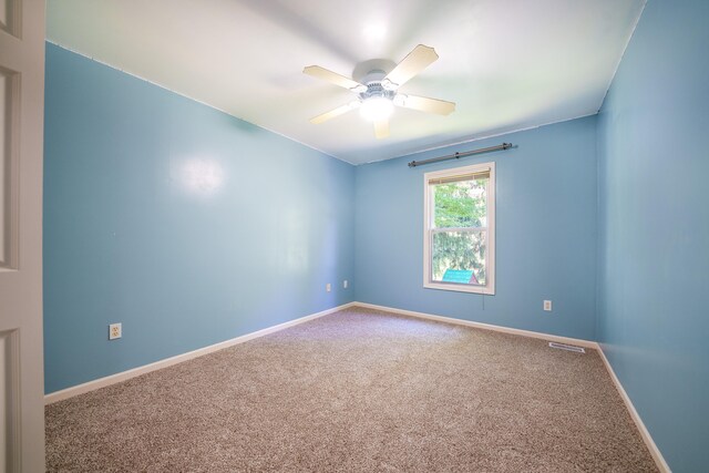 carpeted spare room featuring ceiling fan