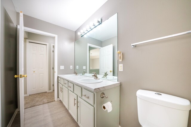 bathroom with vanity, toilet, and hardwood / wood-style floors