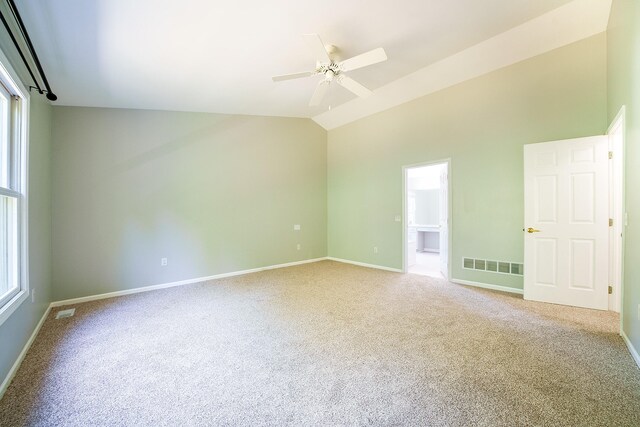 unfurnished room with vaulted ceiling, carpet, and a healthy amount of sunlight