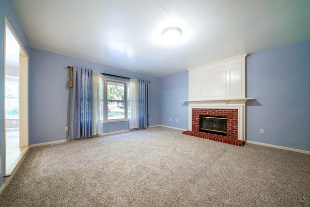 unfurnished living room featuring a brick fireplace and carpet floors