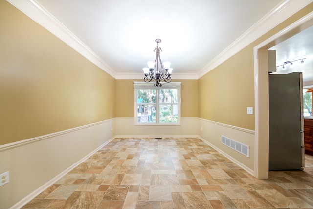 spare room with crown molding and a chandelier