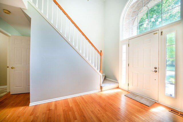 foyer featuring light wood-type flooring and a high ceiling