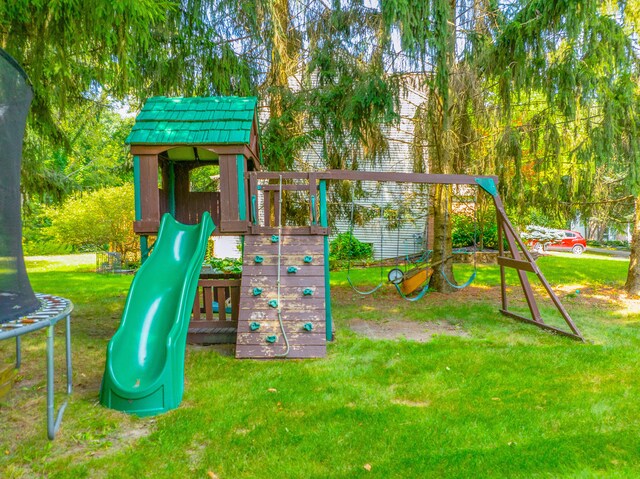 view of jungle gym with a trampoline and a lawn