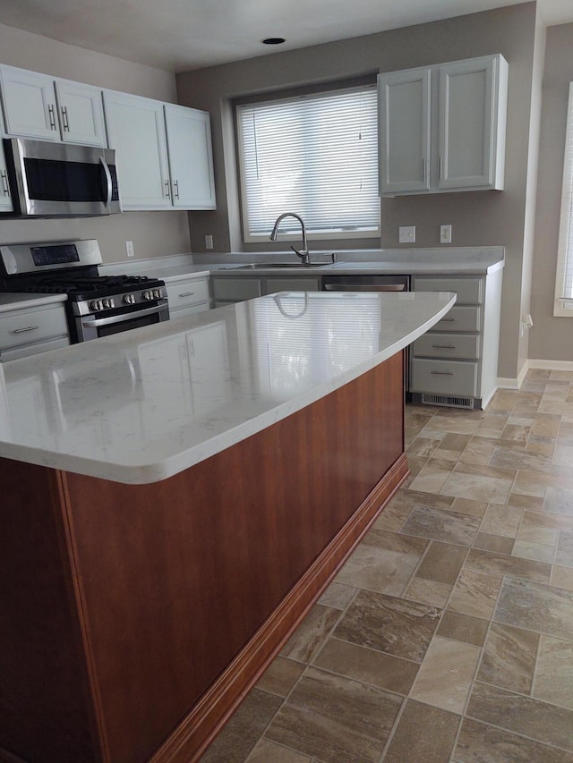 kitchen featuring appliances with stainless steel finishes, sink, and white cabinets