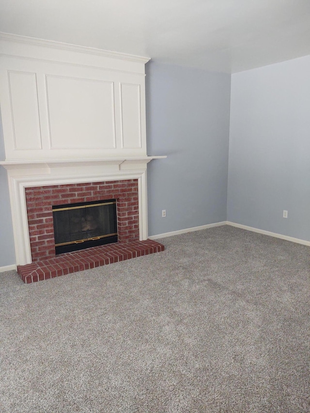 unfurnished living room featuring a brick fireplace and carpet floors