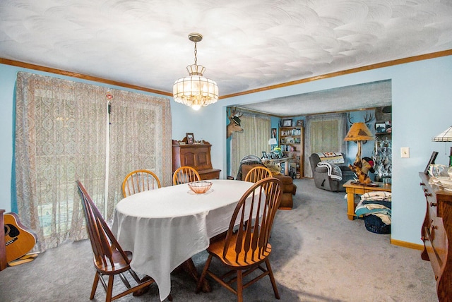 carpeted dining area with baseboards, ornamental molding, and a notable chandelier