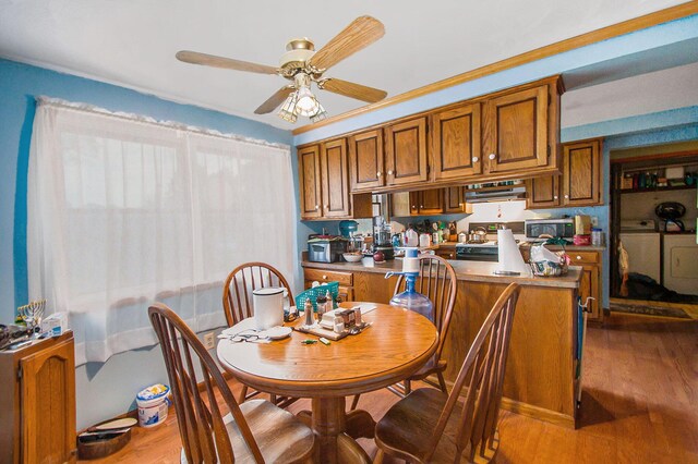 dining space with a ceiling fan, wood finished floors, and washing machine and clothes dryer