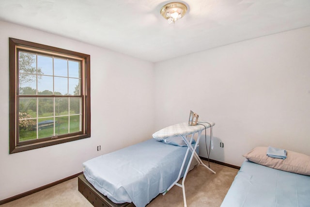 bedroom featuring light colored carpet and baseboards