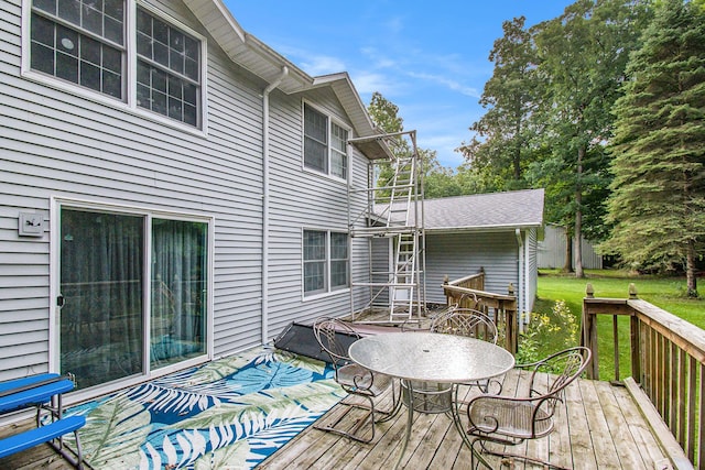 wooden deck featuring a lawn and outdoor dining space