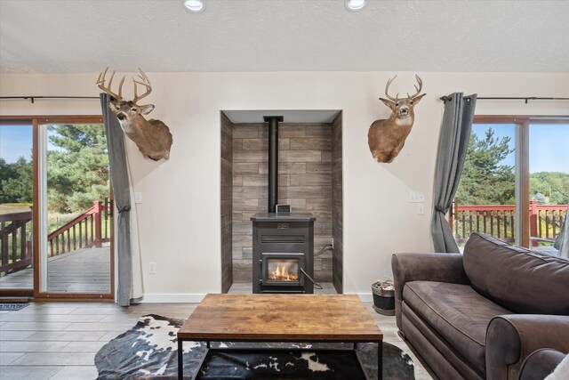 living room with a wood stove and a textured ceiling