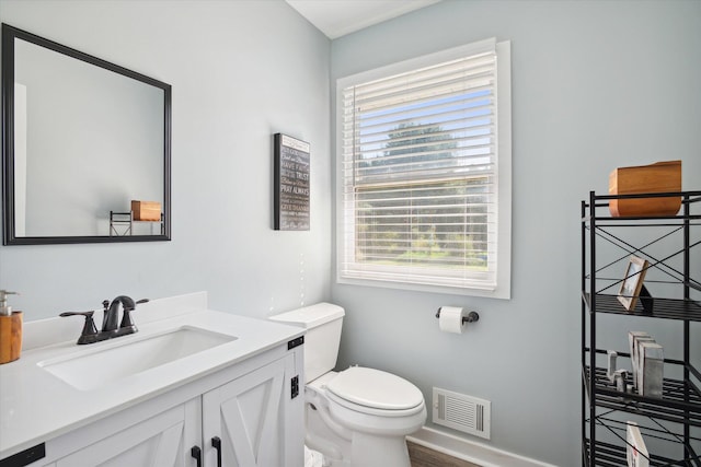 bathroom with vanity, toilet, and hardwood / wood-style flooring